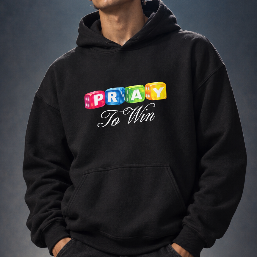 A man wearing a black pullover hoodie with a colorful graphic that reads 'PRAY To Men' in block letters and cursive script, paired with dark cargo pants against a dark studio background.