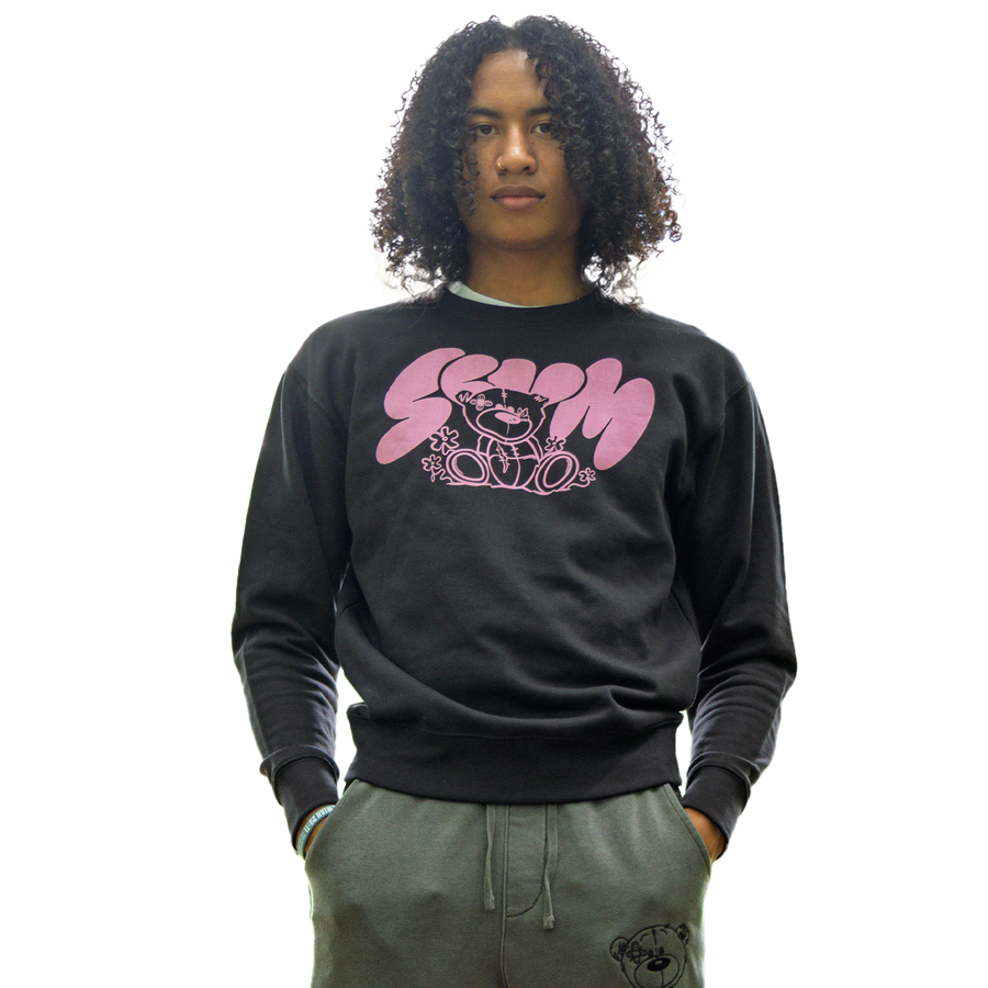 Person wearing a black sweatshirt with pink graphic design on a white background