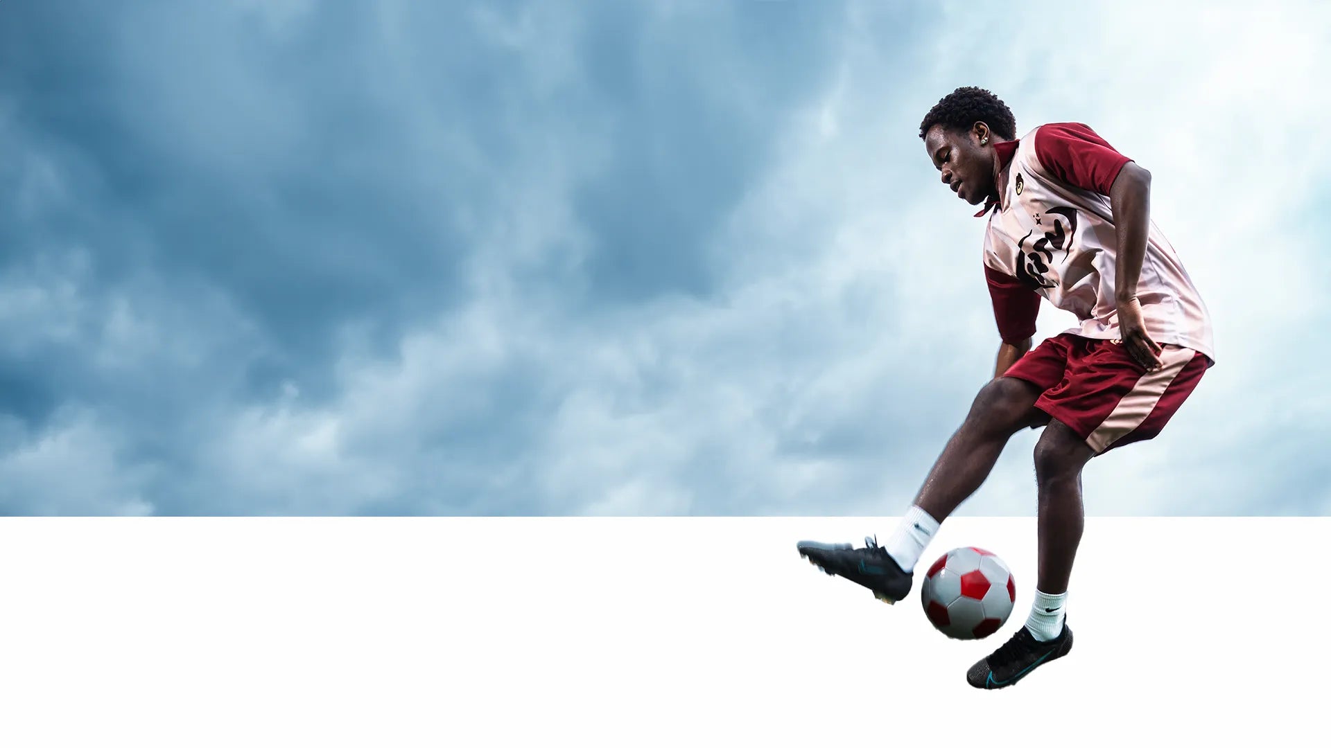 Soccer player in action with a cloudy sky background